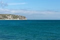 A photo taken on a spring day at Swanage beach looking towards the boats on the sea and the jurasic coast line