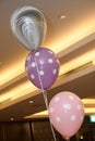 Three balloons of different colors and design prints tied together vertically Royalty Free Stock Photo