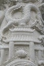 A white washed stone carving of ancient china architecture and an oriental dragon