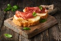 Photo of tasty bread slices with bacon and melon