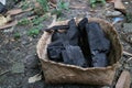 Photo of teak wood briquette charcoal in a bamboo container