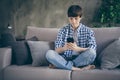 Photo of teenager school boy enjoy sit comfy couch staying home quarantine time hold telephone hands read teacher Royalty Free Stock Photo