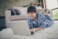 Photo of teenager school boy lying floor carpet near couch stay home quarantine hold notebook online education read Royalty Free Stock Photo