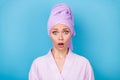 Photo of terrified girl staring camera open mouth wear violet towel turban bath robe isolated blue color background