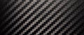 Photo of the texture of black carbon fiber. Carbon dark background of rectangular shape. Black sports film for pasting