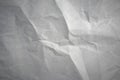 Photo of the texture of a white crumpled sheet of paper. A clean sheet of cardboard with crumpled parts.