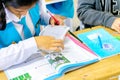 A thai student in sweater is learning with his dictionary in Thai classroom of Wantamaria school Pranburi, Thailand February 6,