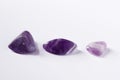 A photo of three amethyst gemstones, natural mineral stones.