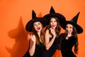 Photo of three cruel witch ladies calling handsome guys using paranormal magic powers wear black dresses and wizard hats