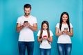 Photo of three family members writing email letters in telephones wear casual outfit isolated blue background