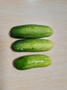 Three green cucumbers combined with white fibrous on a white-brown porcelain floor Royalty Free Stock Photo