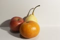 Photo of three kinds of fruit consisting of orange apple and pear