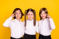 Photo of three minded schoolchildren hard brainstorming wear white shirt isolated yellow color background