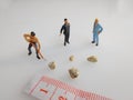 Three mini figure toys arround very small kidney stones top view