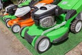 Photo of three new powerful green and orange gasoline lawn mower