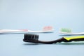 A photo of three tooth brushes on the grey background. Red, black and green toothbrushes. Sanitary hygiene protection, personal ca