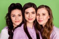 Photo of three young attractive girls happy positive smile girlfriends isolated over green color background