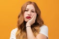 Photo of tired girl with wavy redhead, covers face hand, feels fatigue, needs good rest, has sleepy expression