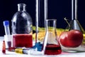 Tomatoes, syringe, test tubes in laboratory on table. Genetically modified food conception Royalty Free Stock Photo