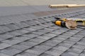 Asphalt tile roof and tool belt lying on new house under construction Royalty Free Stock Photo