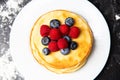 Photo from top of plate with pancakes, blueberries, raspberries