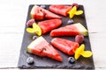 Slices of watermelon, fruit ice, frozen blueberries, raspberries on black board Royalty Free Stock Photo