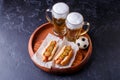 Photo on top of two glasses of beer and hot dogs on wooden tray with football Royalty Free Stock Photo