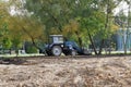 Photo of a tractor carrying earth in a bucket.