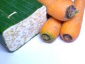 A photo of traditional Indonesian tempeh and a bunch of carrots.