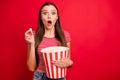 Photo of trendy scared brunette terrified girl eating pop corn wearing striped t-shirt watching horror movie while