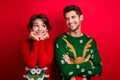 Photo of tricky cunning married couple wear ornament sweaters arms cheeks looking each other isolated red color
