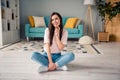 Photo of tricky cunning young girl wear pink t-shirt finger chin sitting floor legs crossed indoors home room