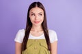 Photo of tricky cute young woman dressed white t-shirt looking empty space smiling isolated violet color background