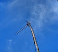 This is a photo of a TV antenna outside the house under the blue sky Very unique and aesthetic