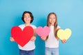 Photo of two affectionate children presenting heart figures wear white t-shirt isolated blue color background Royalty Free Stock Photo