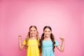 Photo of two beautiful small ladies best friends indicating fingers up empty space advising new low sale prices wear Royalty Free Stock Photo