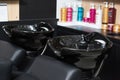 Photo of two black ceramical hair sinks standing in beaty salon. Royalty Free Stock Photo