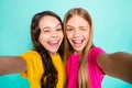 Photo of two casual nice cute excited funny people girls loving taking photos photographing themselves while isolated