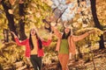 Photo of two cheerful girls fellows enjoy throw catch air fly maple leaves wear red yellow season outfit in autumn Royalty Free Stock Photo