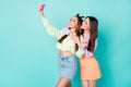 Photo of two cheerful ladies best friends hold telephone take selfies showing v-sign symbol wear cropped sweaters naked Royalty Free Stock Photo