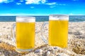 Photo of two cold beer bottle in the sand on the beach Royalty Free Stock Photo