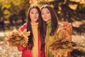 Photo of two dreamy gorgeous two people girlfriends collect hold maple leaves for october date send air kiss boyfriends