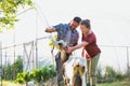 Photo of Two farmers, husband and wife tending to their goat on their farm