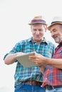 Two farmers using digital tablet in field