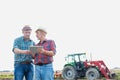 Cropped image of two farmers using digital tablet in field