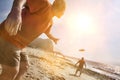 Portrait of Two Friends Throwing Frisbee on Beach with lens flare