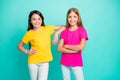 Photo of two funny white friendly kind nice cute girls wearing yellow and pink t-shirts while isolated with teal