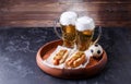 Photo of two glasses of beer and hot dogs on wooden tray with football Royalty Free Stock Photo