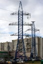 Photo of two high-voltage towers against the background of a modern house. Royalty Free Stock Photo