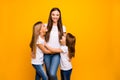 Photo of two little ladies with lovely babysitter wear casual outfit isolated yellow background Royalty Free Stock Photo